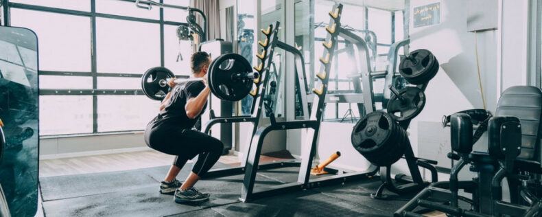 Man doing squats in a gym