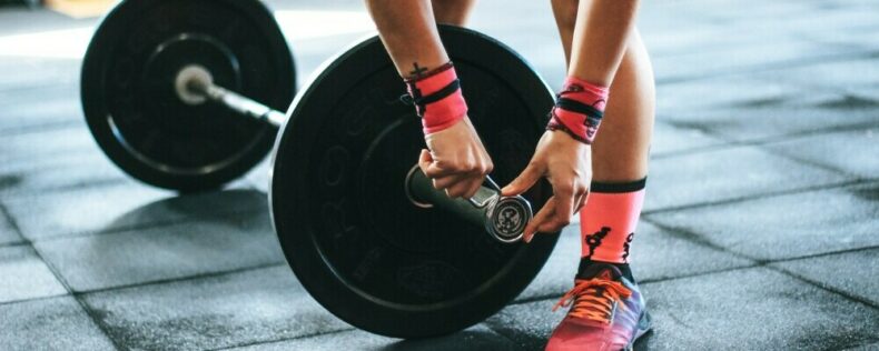 Person loading plates onto a barbell