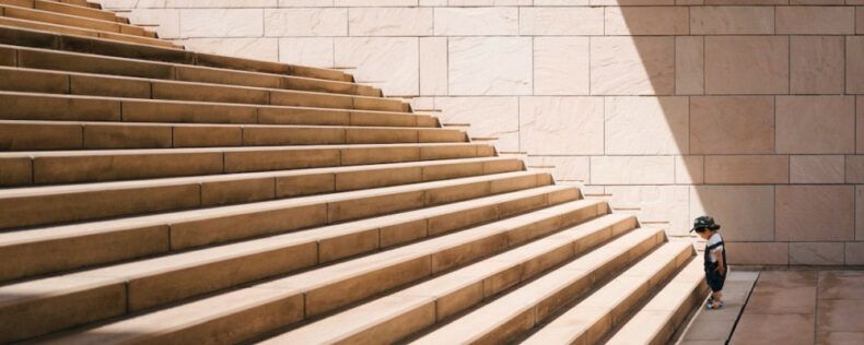 A kid at the foot of a staircase