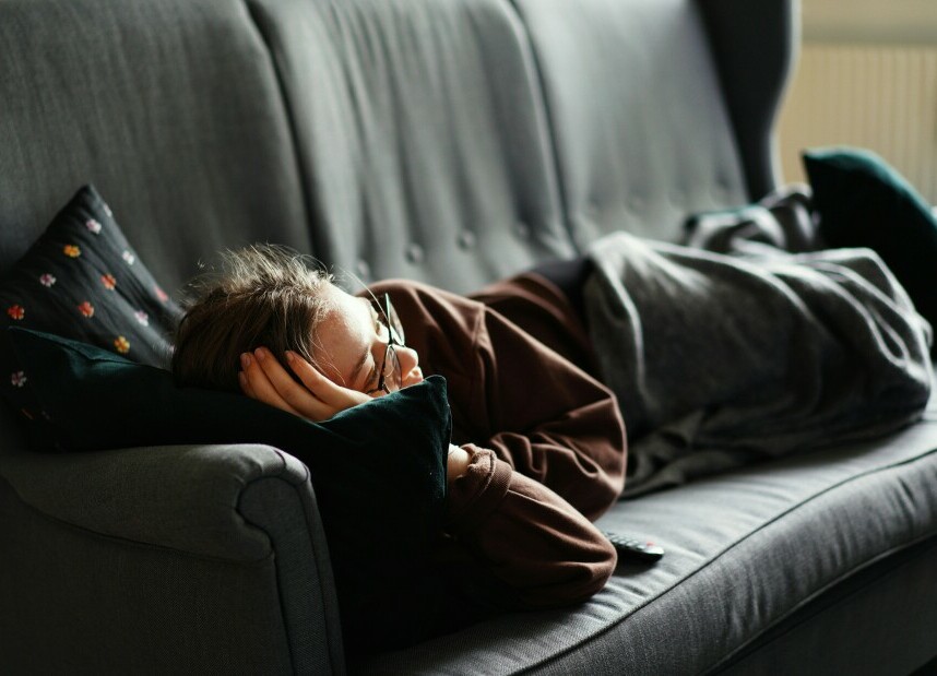 A person napping on a couch